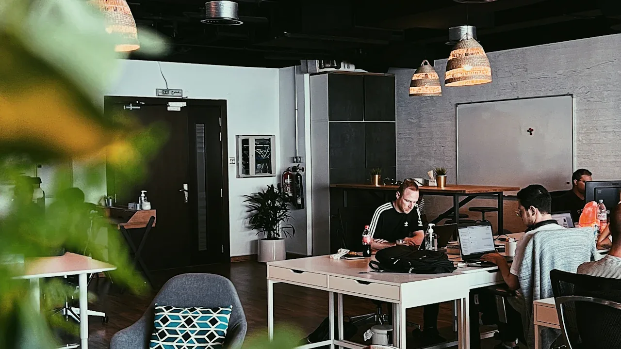 Colleagues working at desks in a bright open-plan studio