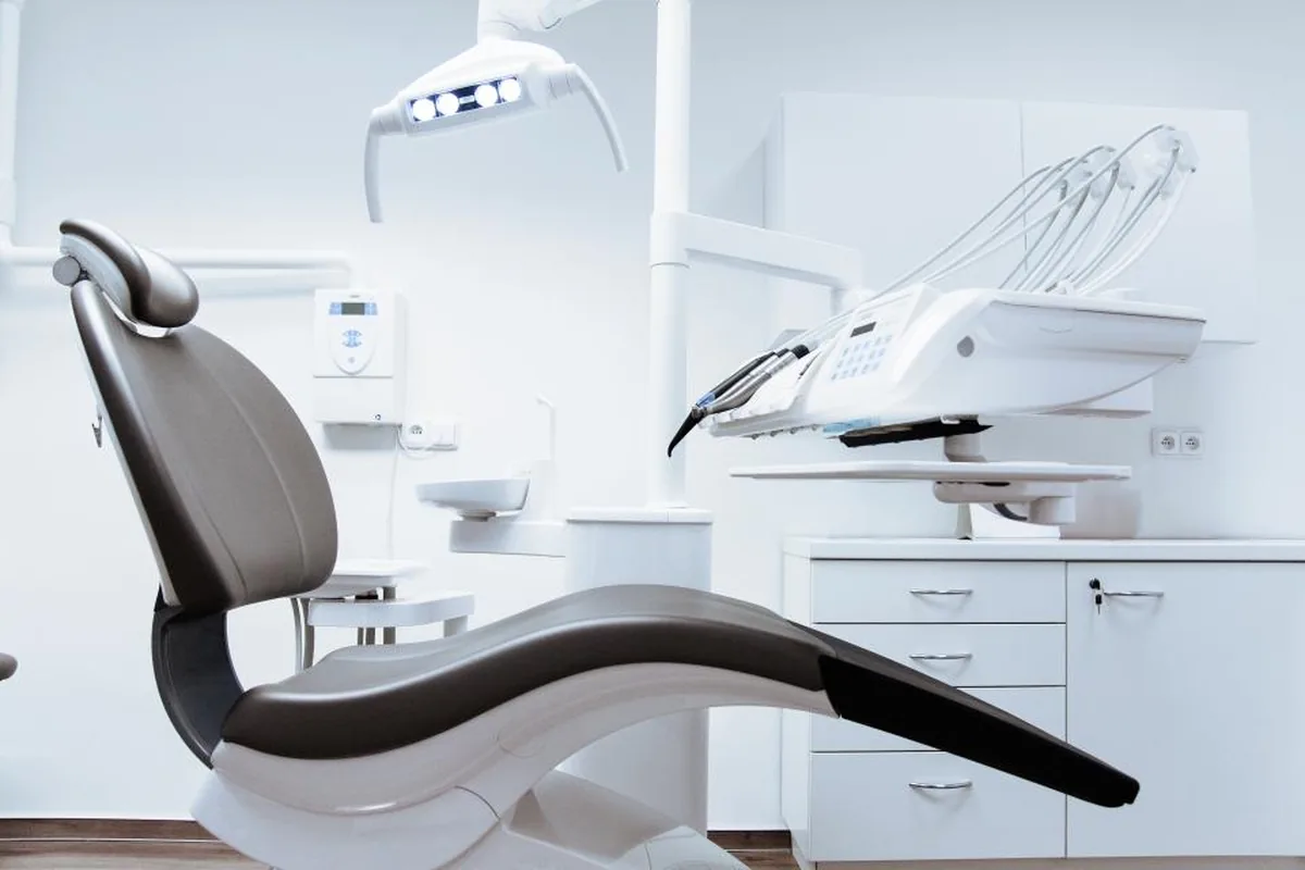 A dental chair and overhead lamp in a treatment room