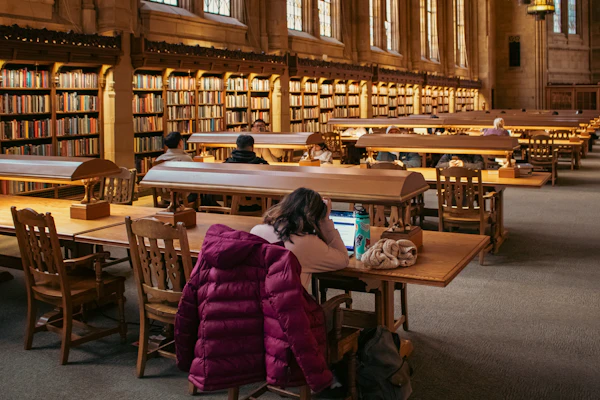 Students studying at desks in a large university library