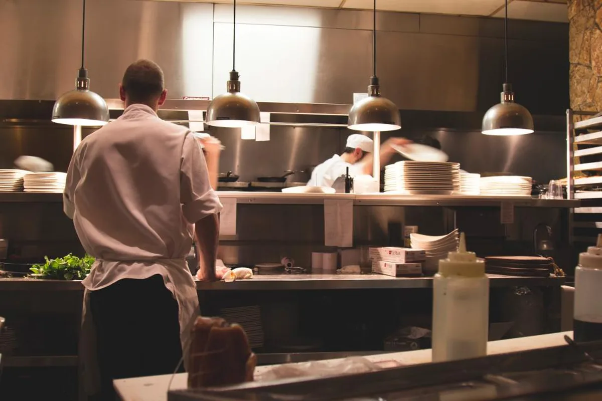 Chefs working at the pass in a restaurant kitchen