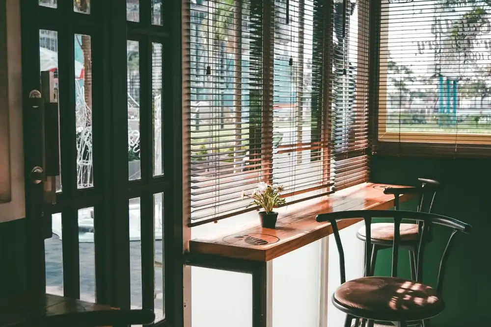 Tables and chairs by the window of an empty cafe