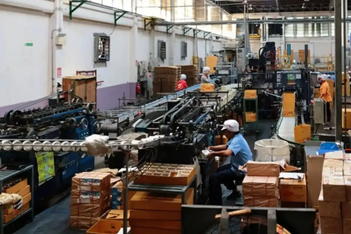 Workers among production machinery on a factory floor