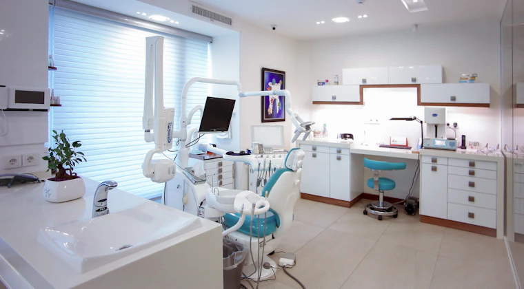 A modern dental treatment room with equipment and chair