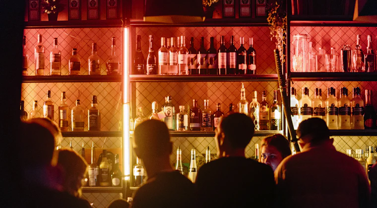 Guests seated at a busy bar in the evening