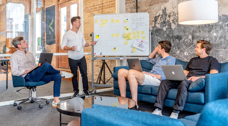 A team working through a strategy session at a whiteboard