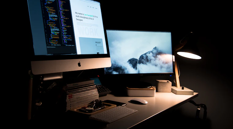 A laptop and notebook on a desk during a website build