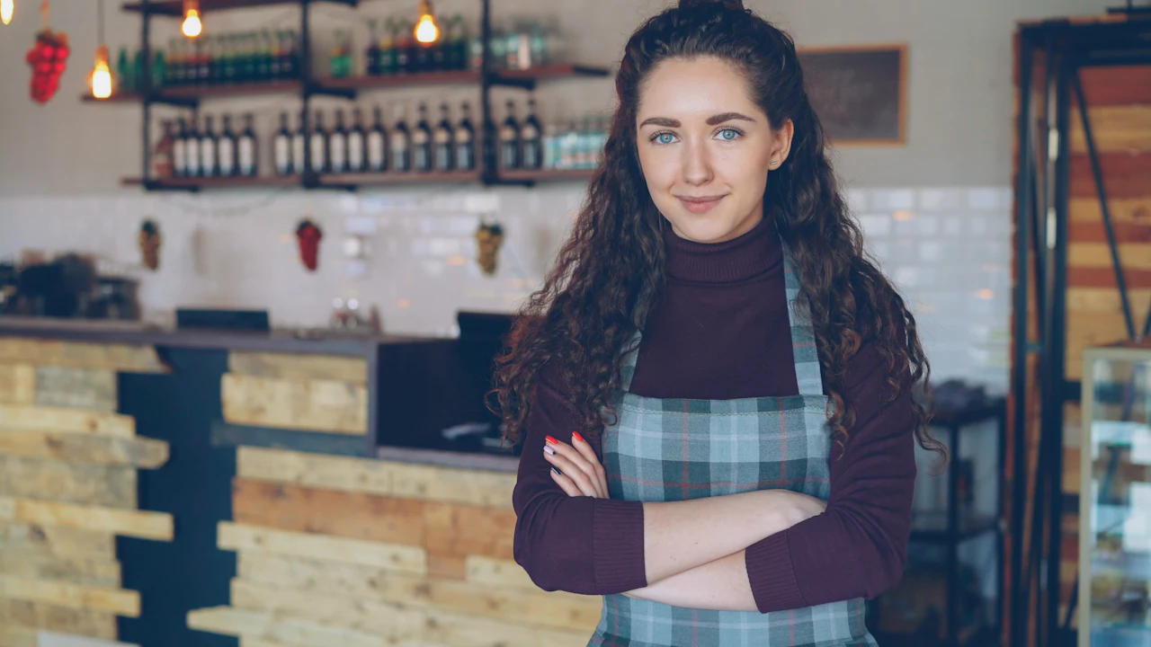 Cafe owner standing in front of the counter of her shop