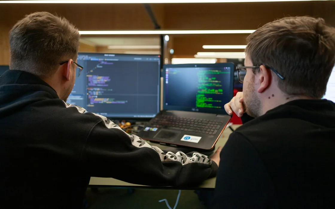 Two people working through a website together on a laptop