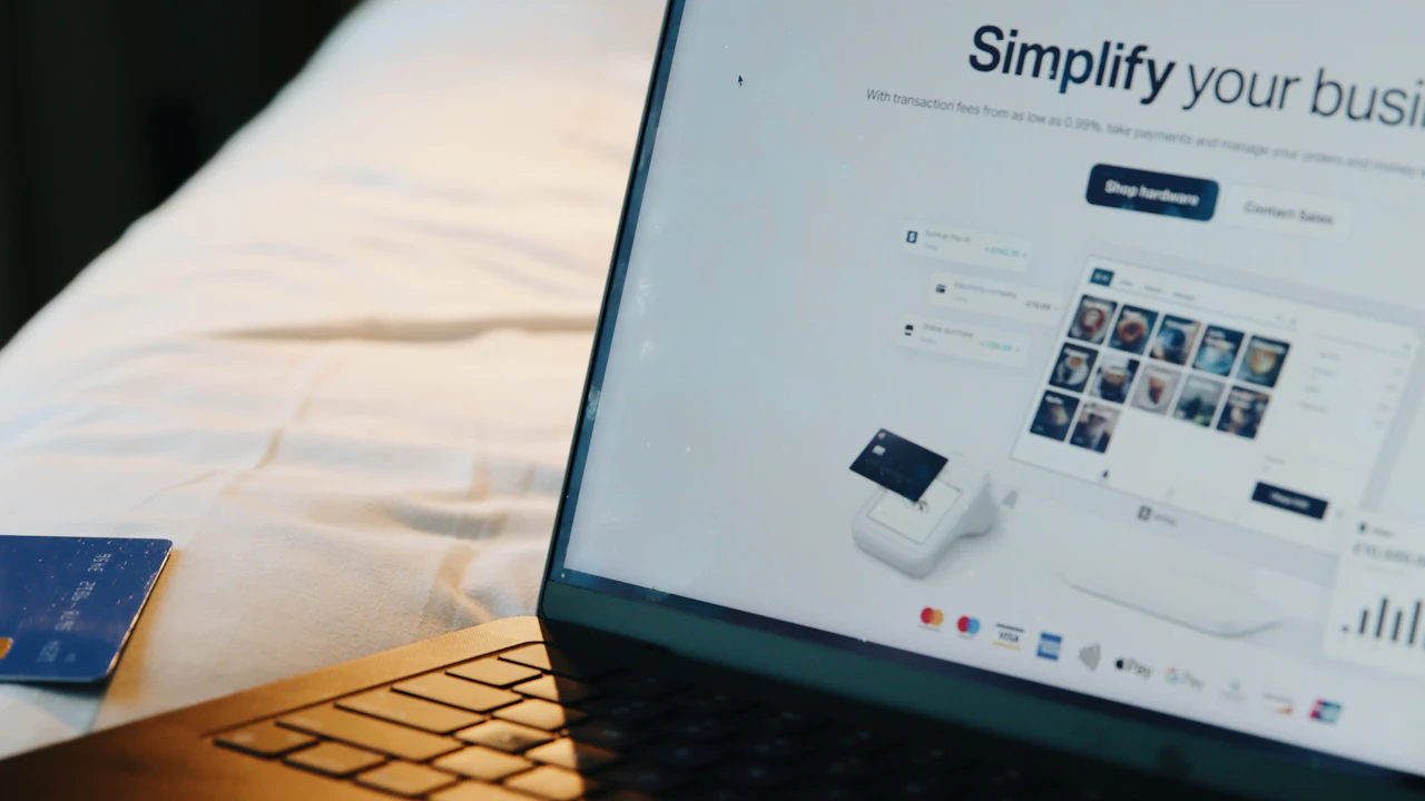Laptop displaying a business website beside a bank card